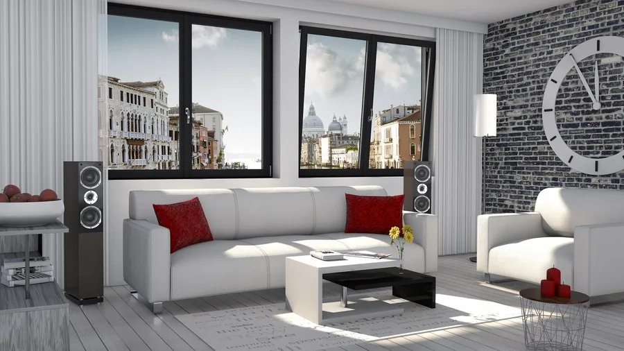 Helles Wohnzimmer mit bodentiefen dunklen Fenstern und Blick auf eine Stadt am Wasser.