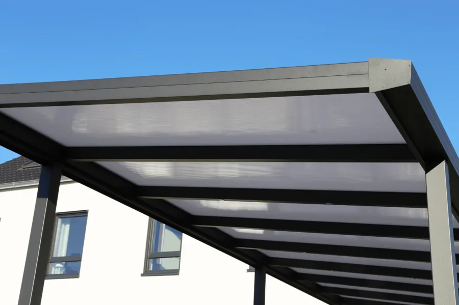Untersicht einer anthrazitfarbenen Terrassenüberdachung vor blauem Himmel.